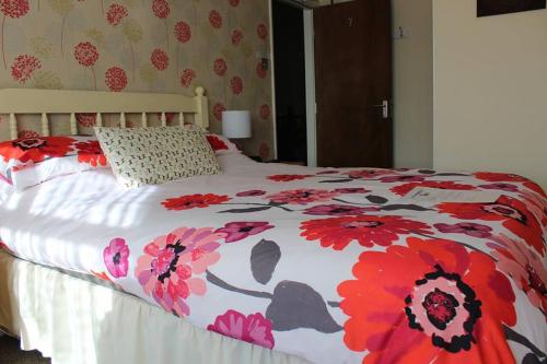 a bed with a white comforter and pillows at The Mayfair in Skegness