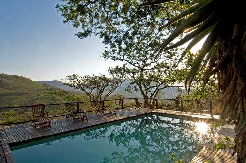 a swimming pool with a view of the water at Three Tree Hill Lodge in Bergville