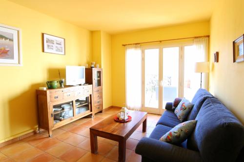 a living room with a blue couch and a table at Apartament Antic Plankton - Calella Palafrugell - Free Parking, Beach, Wifi, Perfect holidays in Calella de Palafrugell