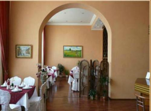 a dining room with red and white tables and an archway at Hotel European in Dnipro