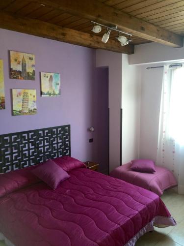 two beds in a bedroom with purple walls at Da Francesca in Scilla
