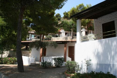 ein weißes Haus mit einem Baum davor in der Unterkunft Villaggio Marina Del Capo Capo Vaticano in Ricadi