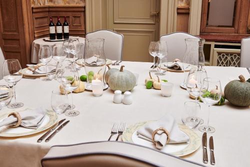 a table with a white table cloth and wine glasses at Hotel Royal Astrid in Aalst