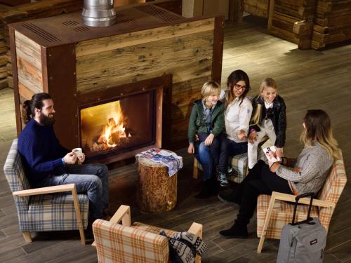 a group of people sitting in front of a fireplace at TH Pila in Pila
