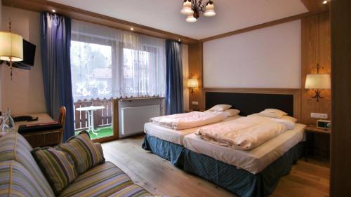 a hotel room with two beds and a couch at Wellness Hotel Bayerischer Hof in Rimbach