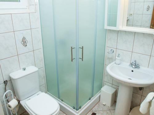 a bathroom with a shower and a toilet and a sink at Lozna Apartment in Postira