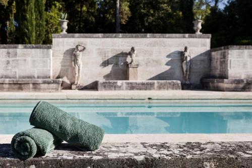 a green rock sitting next to a swimming pool at Villa Poggiano in Montepulciano