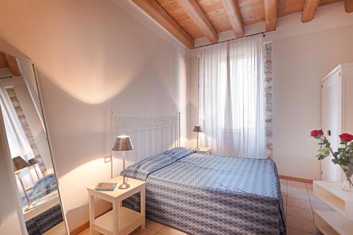 ein Schlafzimmer mit einem Bett und einem Tisch mit einer Lampe in der Unterkunft Residence San Lorenzo in Verona