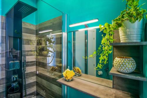 a bathroom with blue walls and a glass shower at Allegra's House Caracciolo in Rome