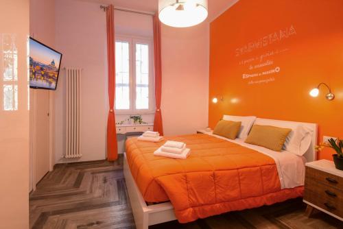 ein Schlafzimmer mit einem orangenen Bett in einem Zimmer in der Unterkunft Allegra's House Caracciolo in Rom