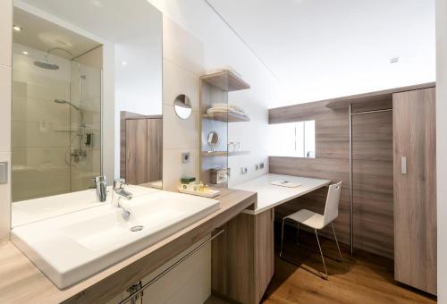 y baño con lavabo grande y ducha. en Landhotel Weißes Roß, en Illschwang