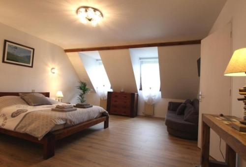 a bedroom with a large bed and a couch at LES CHAMBRES DU GAVE D'OSSAU in Arudy