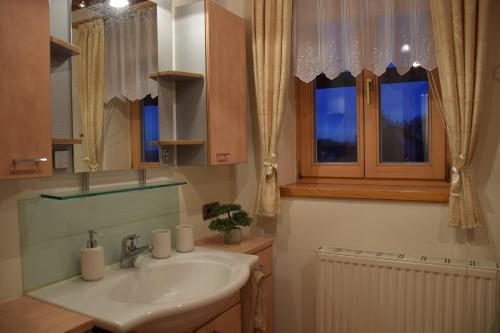 a bathroom with a sink and a mirror and windows at Ferienwohnung in Ilz