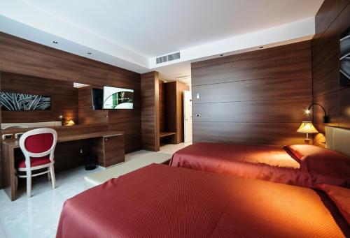 a hotel room with two beds and a desk at Family Center Hotel in Polla