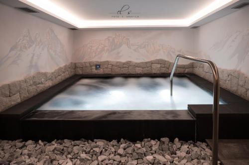 a hot tub in a room with a mountain mural at Residence Lastè in Moena