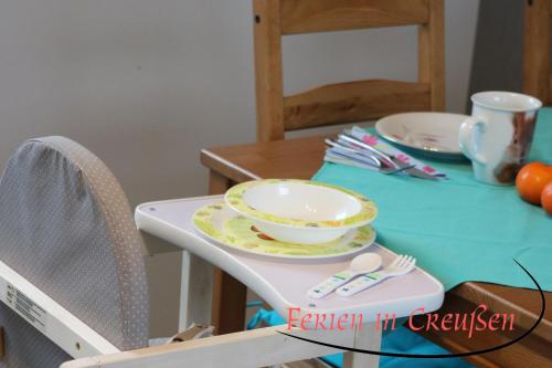 a table with a plate and a bowl on a chair at Ferien in Creußen in Creußen
