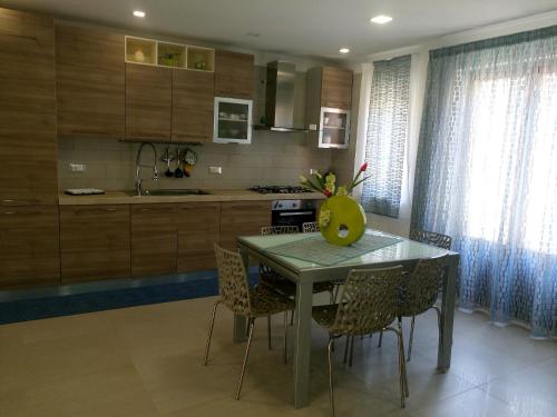 a kitchen with a table and chairs in a room at Appartamento New in Castellammare del Golfo