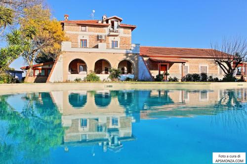 a house with its reflection in the water at Casale Del Vento in Aprilia