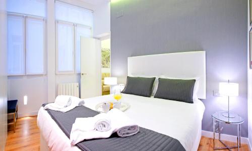 マドリードにあるPrado Suite - MADFlats Collectionのベッドルーム1室(白い大型ベッド1台、タオルトレイ付)