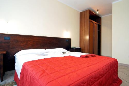 a bedroom with a large bed with a red blanket at Agriturismo Tenuta Regina - Glamping luxury lodges and apartments in Palazzolo dello Stella