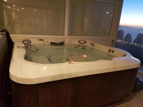 a bath tub in a bathroom with a window at Departamento Full en Reñaca-Concon in Viña del Mar