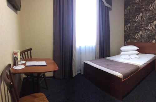 a room with a bed and a table and a window at Hotel LaMa 2 in Kyiv