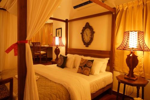 Sriperumbudur的住宿－海尼斯特別墅酒店- 奧拉加達姆- 斯里佩魯姆布杜爾，一间卧室配有一张带两盏灯的床和一张书桌。