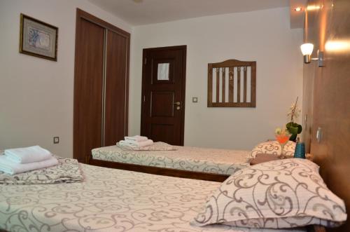 a bedroom with two beds and a door to a room at Family Hotel BOHEMA in Ognyanovo