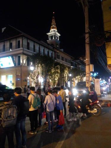 a group of people standing on a street at night at Chill Chill at Nimman in Chiang Mai