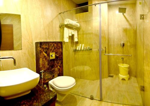 uma casa de banho com um chuveiro, um WC e um lavatório. em The Dwarika Hotel em Dwarka