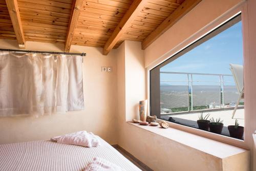 a bedroom with a window with a bed and a view at Pantanassa Villa Thalia in Agia Marina Nea Kydonias