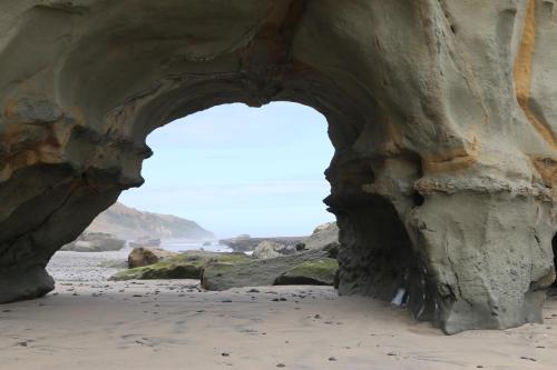 an arch in a rock wall on the beach at Wetland View Park in Anatori