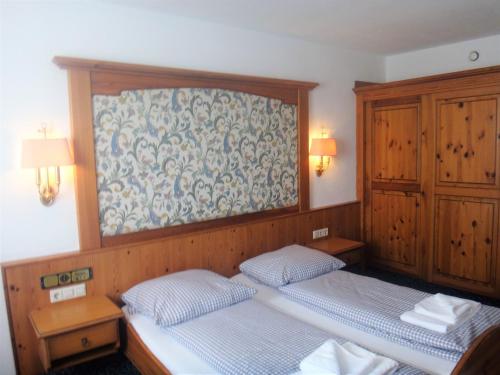 two twin beds in a room with wooden walls at Bodenseehotel Lindau in Lindau