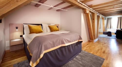 a bedroom with a large bed in a room with wooden ceilings at Home Hotel Bryggeparken in Skien