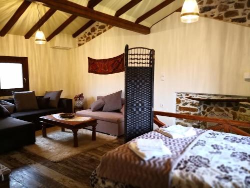 a living room with a bed and a couch at Effrosini Stonehouse Portaria in Portariá