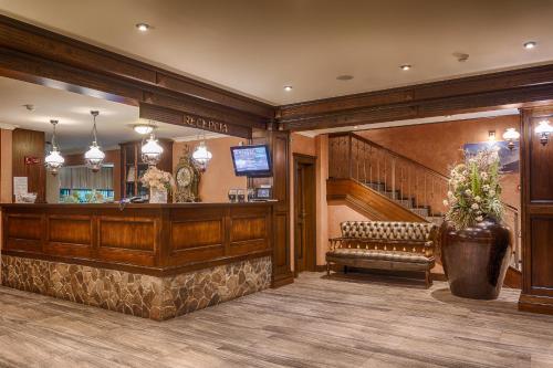 una hall con bar con panchina e scale di APLEND Wellness Hotel Borovica a Štrbské Pleso