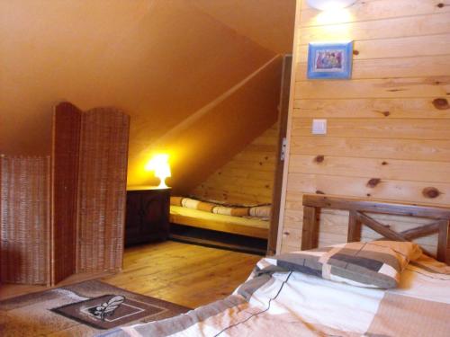 a bedroom with a bed and a wooden wall at Agroturystyka Zacisze Czarna Owca in Brzeżanka