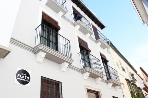 un edificio blanco con balcones y una señal en él en Nest Flats Granada, en Granada
