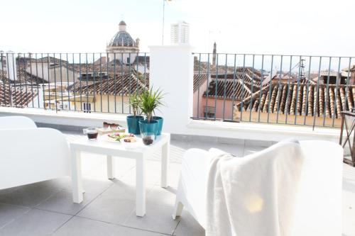 a white table and chairs on a balcony with a view at Nest Flats Granada in Granada
