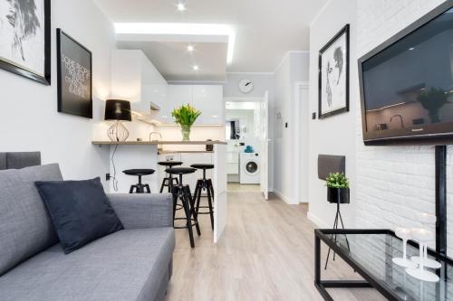 a living room and kitchen with a couch and a table at Elite Apartments SPA Zone in Gdańsk