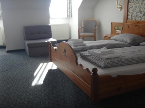 a bedroom with a wooden bed and a chair and a chair at Bodenseehotel Lindau in Lindau