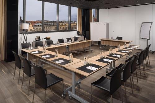 a large conference room with a long table and chairs at INNSiDE by Meliá Leipzig in Leipzig