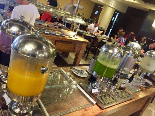 a counter with a bunch of drinks in a restaurant at Flat Wish Serrano Hotel in Gramado