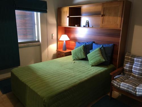 ラゴスにあるSilver Moon Beach Houseのベッドルーム(緑のベッド1台、椅子付)