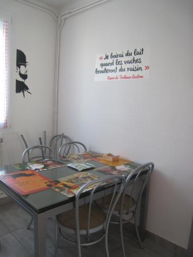 アルビにあるChambres d'hôtes Albi villeの壁に看板のある部屋(椅子付きテーブル付)