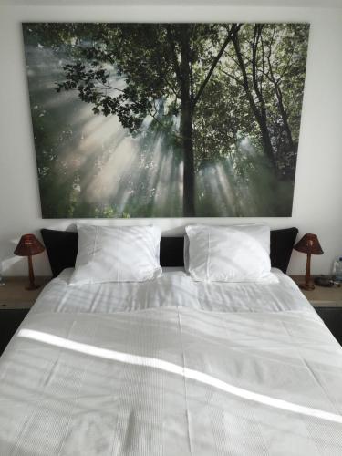 een slaapkamer met een wit bed en een schilderij aan de muur bij Apartment Gronau in Gronau