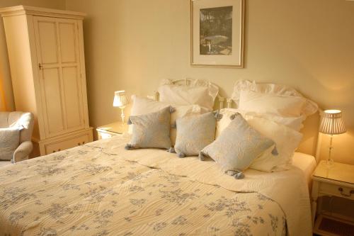a bedroom with a white bed with white pillows at Courtland in Stratford-upon-Avon