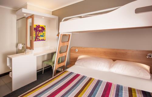 Jest to pokój wieloosobowy z łóżkiem piętrowym i biurkiem. w obiekcie SUN1 PORT ELIZABETH w mieście Port Elizabeth
