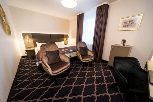 a hotel room with two chairs and a bed at Hotel Kaiserhof in Münster