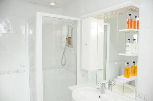 a white bathroom with a shower and a sink at The Inn At Lathones in St. Andrews